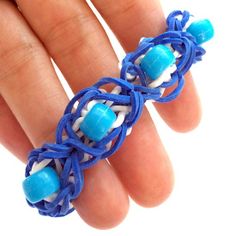 a woman's hand wearing a blue ring with beads on the inside and outside