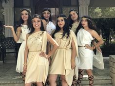 a group of young women dressed in ancient greek garb posing for a photo together