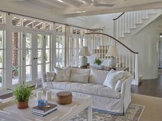 a living room filled with furniture next to a stair case in front of a window