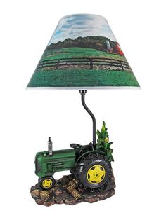 a lamp that has a tractor on it and a green shade over the light fixture