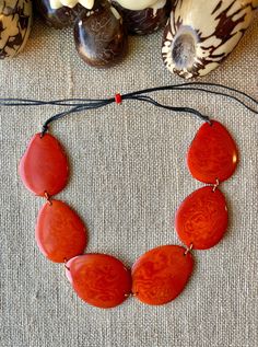 Handmade in Ecuador Necklace Length: Adjustable Length 14 -31 Inches Due to this item being handmade and the nature of the Tagua Nut the size and the color may vary from piece to piece Adjustable Orange Artisan Necklace, Artisan Orange Adjustable Necklace, Artisan Adjustable Orange Necklace, Fair Trade Orange Jewelry Gift, Orange Fair Trade Jewelry Gift, Adjustable Handmade Orange Necklaces, Handmade Adjustable Orange Necklace, Artisan Adjustable Natural Color Necklaces, Artisan Adjustable Natural Necklaces