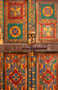 an ornate wooden door with colorful designs on it