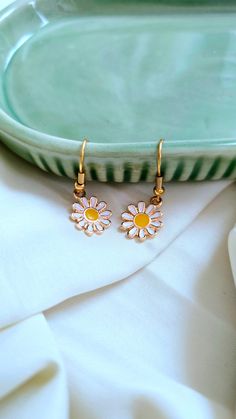 Add a touch of whimsy to your outfit with our Daisy Earrings. These adorable daisies will bring a smile to your face and brighten up any look. Perfect for adding a playful touch to your style. 🌼 Earring Details: White daisies Gold furnishings White Flower-shaped Trendy Earrings, Trendy White Flower-shaped Earrings, White Earrings With Ear Wire For Spring, Spring White Earrings With Ear Wire, Whimsical Spring Earrings For Pierced Ears, White Nickel Free Flower Earrings For Spring, Nickel-free White Earrings For Spring, White Nickel-free Flower Earrings For Spring, Spring White Nickel-free Flower Earrings