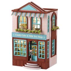 a doll house with a pink and blue awning