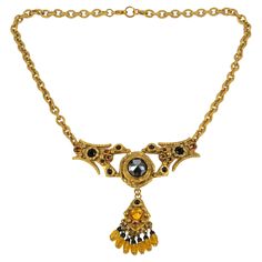 This is a stunning Henry Perichon (aka Henry), Medieval revival gilded bronze pendant necklace. The bronze metal pendant with antique Middle-Age design influences is ornated with faceted French black jet glass cabochons, orange topaz, and yellow citrine crystal rhinestones. Heavy gilded bronze worked chain. The pendant is engraved "Henry Paris" on the back, and the choker has a lobster closing clasp. The necklace is in good condition, with wear on gilded bronze due to regular use. Measurements: Ornate Jeweled Necklaces, Ornate Yellow Gold Necklace With Jewels, Ornate Antique Gold Jewelry With Historical Design, Victorian Jeweled Gold Jewelry, Victorian Style Jeweled Gold Jewelry, Bronze Ornate Jewelry With Historical Design, Victorian Jeweled Pendant Necklace, Antique Gold Baroque Necklaces, Antique Gold Baroque Necklace