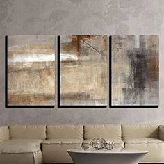 three paintings hanging on the wall above a white couch in a living room with a coffee table