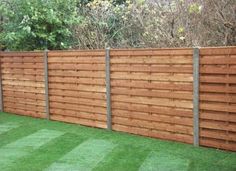 a wooden fence with grass in the foreground