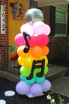 there is a musical note made out of balloons on the front steps of a house