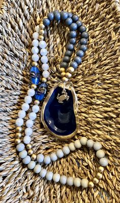 a blue and white beaded necklace on a woven surface