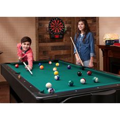 a young boy and girl are playing pool