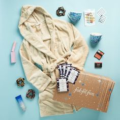 the contents of a bathrobe laid out on a blue surface with other items