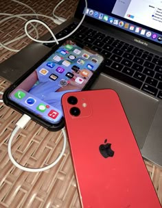 two iphones are sitting next to an open laptop