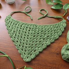 a crocheted green triangle on a wooden table