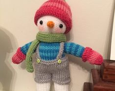 a knitted snowman doll hanging on the wall