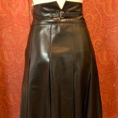 This Prada Skirt Is A Must-Have For Any Fashion-Forward Woman. Crafted From High-Quality Leather, The Skirt Features A Unique Pleated Design With The Iconic Prada Logo Buckle. The Skirt Is Perfect For Any Season, Whether It's Winter, Fall, Or Spring, And Is Sure To Turn Heads Wherever You Go. The Skirt Is Available In Size 6 And Has A Knee-Length Hemline With A High-Rise Waist. It Is Perfect For Casual Or Formal Occasions And Can Be Paired With A Variety Of Tops And Shoes. Made In Italy, This Vi Formal Leather Skirt With Belt Loops, Classic Black Skirt With Belt Loops, Black Luxury Long Skirt, Luxury Long Black Skirt, Elegant Leather Skirt With Belt Loops, Luxury Fitted Leather Skirt, Luxury Black Long Skirt, Designer Fitted Leather Skirt, Formal Leather Flared Skirt