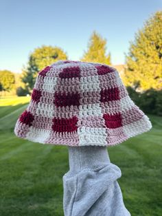 a person wearing a crocheted hat with red and white squares