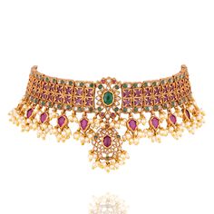 Where tradition meets magnificence, a timeless masterpiece of opulence! Step into a world of regal splendor with this exquisite set, a harmonious blend of tradition and modern grandeur. This captivating ensemble features a meticulously crafted set adorned with a lattice of ruby and dazzling emerald stones, encircled by radiant kundan stones, exuding an aura of unparalleled elegance. The set includes a necklace and a pair of matching earrings. Approximate earrings length is 1.2". Gold-plated on h Elegant Ceremonial Sets For Diwali, Classic Gold Sets For Festive Season, Classic Gold Festive Sets, Classic Gold Festive Set, Elegant Kundan Sets With Intricate Design, Elegant Festive Sets With Intricate Design, Elegant Kundan Sets For Ceremonial Occasions, Elegant Red Sets For Ceremonial Occasions, Elegant Kundan Formal Sets