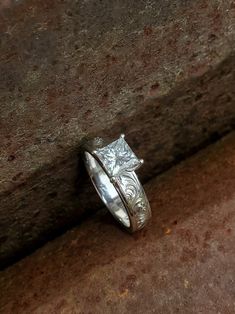 a silver ring sitting on top of a rock