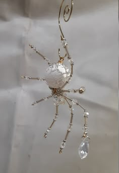 "This is a handmade beaded crystalline ice spider. The abdominal area is made from a larger frosted clear crystal bead with a smaller faceted clear bead for the head. The legs are made from flexible but sturdy 21 ga. brass wire which are covered with small clear Swarovski Glass beads and can be carefully adjusted to almost any position. Silver bead caps are also incorporated into the body. A gold decorative hook is attached to the back of the abdomen and can be used to hang the spider or be remo Spider Jewelry Diy, Beaded Spider Web, Spider Beads, Bead Bugs, Christmas Spiders, Beaded Insects, Wire Spider, Beaded Bugs, Steampunk Christmas