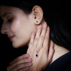 a close up of a person wearing an earring and holding her hand near her ear