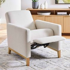 a white chair sitting on top of a rug in a living room