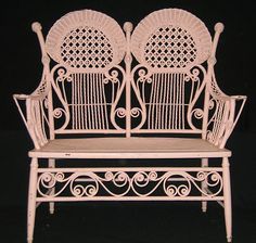 two white wrought iron chairs sitting next to each other on a black background with one chair facing the other way