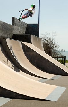 a man riding a skateboard up the side of a ramp at a skate park