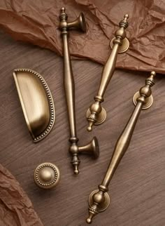 three antique style handles and knobs on a wooden surface