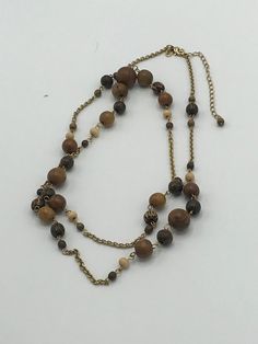 Lia Sophia gold and wood necklace, brown, pearl Elegant Long Necklaces With Wooden Beads, Brown Beaded Long Necklace For Gift, Earthy Gold Beaded Necklaces, Elegant Long Brown Beaded Necklaces, Elegant Brown Long Necklace With Round Beads, Gold Long Beaded Necklaces With Wooden Beads, Earthy Brown Beaded Necklace With Wooden Beads, Elegant Brown Necklaces With Gold Beads, Brown Long Necklace In Costume Jewelry Style