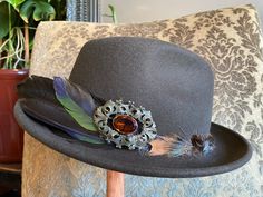 All of my creations are hand picked, hand crafted and one of a kind. My hats are inspired by the Victorian Era and art forms like Art Nouveau and Art Deco. All of my pieces bring a sense of elegance by intertwining the old and new. Each hat is hand picked and then dressed up with feathers, stone beads, a stone cabochon and a vintage cameo. No single hat is the same and all hats are designed to be their own. All the names are based off of my close friends or a song from one of my favorite musicia Adjustable Fedora For Formal Occasions, Custom Adjustable Fedora For Formal Occasions, Formal Handmade Hat With Curved Brim, Handmade Formal Hat With Curved Brim, Handmade Formal Hats, Handmade Adjustable Formal Hats, Handmade Vintage High Crown Top Hat, Vintage Black Handmade Top Hat, Vintage Handmade Adjustable Felt Hat