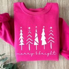 This Merry and Bright sweatshirt in Hot Pink is perfect for this holiday season whether you are cozying up with a good book or a holiday movie, going to a holiday function or getting your Christmas tree, this cozy sweatshirt is a great choice and makes a beautiful gift too. Check out the rest of our store here--> https://coastcountrydesign.etsy.com These garments are made from polyester and cotton. This combination helps designs come out looking fresh and beautiful. The collar is ribbed knit, so it retains its shape even after washing. There are no itchy side seams on these sweaters.  .: 50% cotton, 50% polyester (fiber content may vary for different colors) .: Medium-heavy fabric (8.0 oz/yd² (271 g/m .: Classic fit .: Tear-away label .: Runs true to size CARE INSTRUCTIONS:  * Turn garment Puff Vinyl Shirt Ideas Christmas, Christmas Sweat Shirts, Pink Christmas Sweatshirt, Cricut Christmas Sweatshirts, Cute Christmas Sweatshirts, Pink Christmas Sweater, Merry Sweatshirt, Diy Christmas Shirts, Merry And Bright Christmas