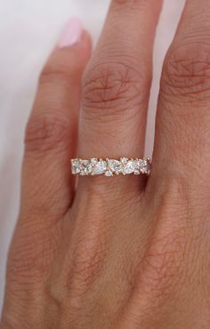 a woman's hand with a wedding band on it and a diamond ring in the middle