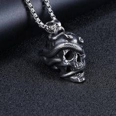 🛠 Dive into the mysterious and captivating world of gothic fashion with our Stainless Steel Snake Wrapped Skull Pendant Necklace.It's punk and gothic for everyday use but also can be preferred as a gift for friends and family for an eternal memorial.  🛠 This necklace chain is also a great gift idea for birthdays, graduations, New Year, Mother's Day, Father's Day, Easter, Thanksgiving and other events. 🛠 A stunning trendy Silver Color Chain necklace every man / woman should have! 🛠 This strik Punk Necklace With Lobster Clasp For Halloween, Alternative Halloween Necklaces For Alternative Fashion, Alternative Halloween Necklaces, Alternative Style Necklaces For Halloween, Alternative Style Halloween Jewelry As A Gift, Punk Necklaces For Halloween Alternative Fashion, Punk Necklaces For Halloween, Punk Metal Necklace With Skull Print, Punk Style Metal Necklace With Skull Print