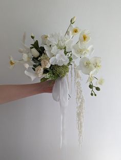 a hand holding a bouquet of white flowers