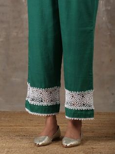 A two piece kurta set comprises of a soft cotton emerald green kurta with crochet fabric details insert on the sleeves along with delicate laces around the body. It is paired with matching culottes with crochet fabric details and lace detailing on the edges. Color: Emerald Green Fabric Composition: Kurta Set - Soft cotton Note: The product will be delivered within 20-25 days of order placed Care Instruction: Dry Clean Only. Do not use heavy Iron Cotton Kurta With Lace Work For Eid, Festive Green Kurta With Lace Work, Traditional Cotton Sets With Lace Work, Green Cotton Kurta With Embroidered Border, Eid Cotton Sets With Cutwork Details, Green Cotton Bohemian Set, Green Bohemian Cotton Set, Spring Cotton Kurta With Lace Work, Green Lace Work Sets For Spring