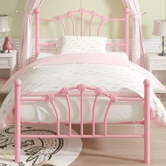 a pink metal bed with white sheets and pillows