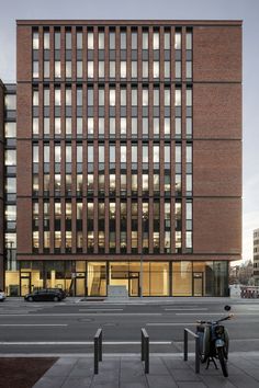 an office building with many windows on the front and side of it, along with two bicycles parked outside