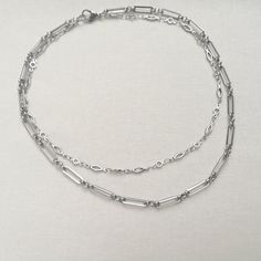 "A minimal stainless steel layered necklace. This chunky chain necklace is made from two lengths of stainless steel chain (the colour is not bright, unlike silver equivalents). This necklace is perfect as a gift for someone special in your life or treating yourself. Great for layering or can be worn on its own. Please note that the chains are joined together at the back and this is not a listing for two separate necklaces. Necklace length options: - 14\" and 16\" (approx. 35.5 cm and 40.5 cm) - 16\" and 18\" (approx. 40.5 cm and 45.5 cm) This necklace is made to order. Packaging: Please choose your packaging type from the drop down menu.                   - Pink card envelope (as shown in the listing photo)                    - White gift box (gift wrapped with tissue paper and a satin bow Minimalist Double Strand Chain Jewelry, Minimalist Double Strand Layered Necklace With Adjustable Chain, Minimalist Double Strand Necklace With Double Chain, Minimalist Double Chain Layered Necklace For Everyday, Everyday Double Chain Necklaces With Rectangular Links, Silver Double Chain Necklace For Gift, Silver Double Strand Chain Necklace For Everyday, Everyday Silver Double Strand Chain Necklace, Minimalist Silver Jewelry With Double Chain