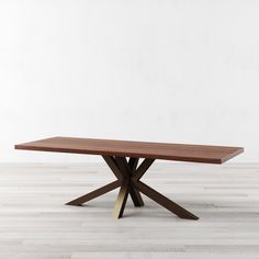 a wooden table sitting on top of a hard wood flooring covered floor next to a white wall