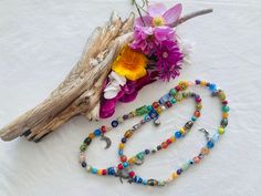 "This cheerful long floral stretchy necklace features 86 glass beads, most of them millefiori, and some small gemstones like, turquoise, jade, agate, cat's eye, howlite, serpentine, 52 silver tone bead dividers and 8 charms, including a lady bug silver charm.  It is 28 inches long and weights  2.5oz. Millefiori  ( Italian) is a glasswork technique which produces distinctive decorative patterns on glassware.  The term millefiori is a combination of the Italian words \"mille' (thousand) and \"fior Hand-strung Glass Bohemian Beaded Necklaces, Hand-strung Bohemian Glass Beaded Necklaces, Bohemian Hand-strung Glass Beaded Necklaces, Bohemian Glass Long Necklace For Gift, Bohemian Glass Long Necklace Gift, Adjustable Multicolor Spiritual Long Necklace, Spiritual Style Long Necklace With Colorful Beads, Spiritual Long Necklace With Colorful Beads, Spiritual Multicolor Long Necklace