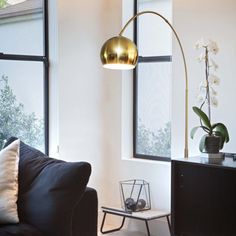 a living room with black couches and large windows in front of the tv set