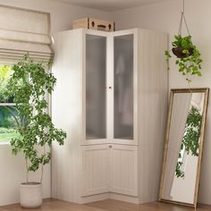 a white cabinet sitting next to a mirror on top of a wooden floor