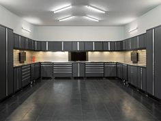 an empty garage with lots of cabinets and drawers