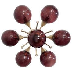 a group of red balls sitting in the middle of a white floor with gold accents