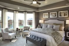 a large bed sitting in a bedroom next to two chairs