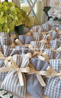 blue and white napkins with bows are on a table next to flowers in vases