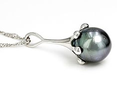 11mm Cultured Tahitian Pearl Rhodium Over Sterling Silver Pendant with Chain. Pendant measures approximately 1 1/4" L x 7/16" W and has a 2.5mm bail. Singapore chain measures approximately inches in length, 1/32 of an inch in width with a lobster claw clasp closure and a 2 inch extender. Colors, shapes, and sizes may vary. Formal Tahitian Pearl Pendant Jewelry, Tahitian Pearl Pendant For Formal Occasions, Tahitian Pearl Pendant Jewelry For Formal Occasions, Tahitian Pearl Pendant Jewelry For Formal Events, Classic Tahitian Pearl Pendant Jewelry, Formal White Gold Jewelry With Tahitian Pearl, Oval Tahitian Pearl Jewelry For Gift, Silver Tahitian Pearl Round Jewelry, Tahitian Pearl Teardrop Jewelry For Formal Occasions