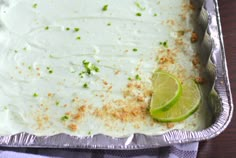 a pan filled with white frosting and limes