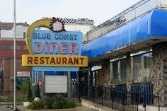 a blue and yellow diner sign in front of a building