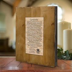 a wooden plaque sitting on top of a table next to candles